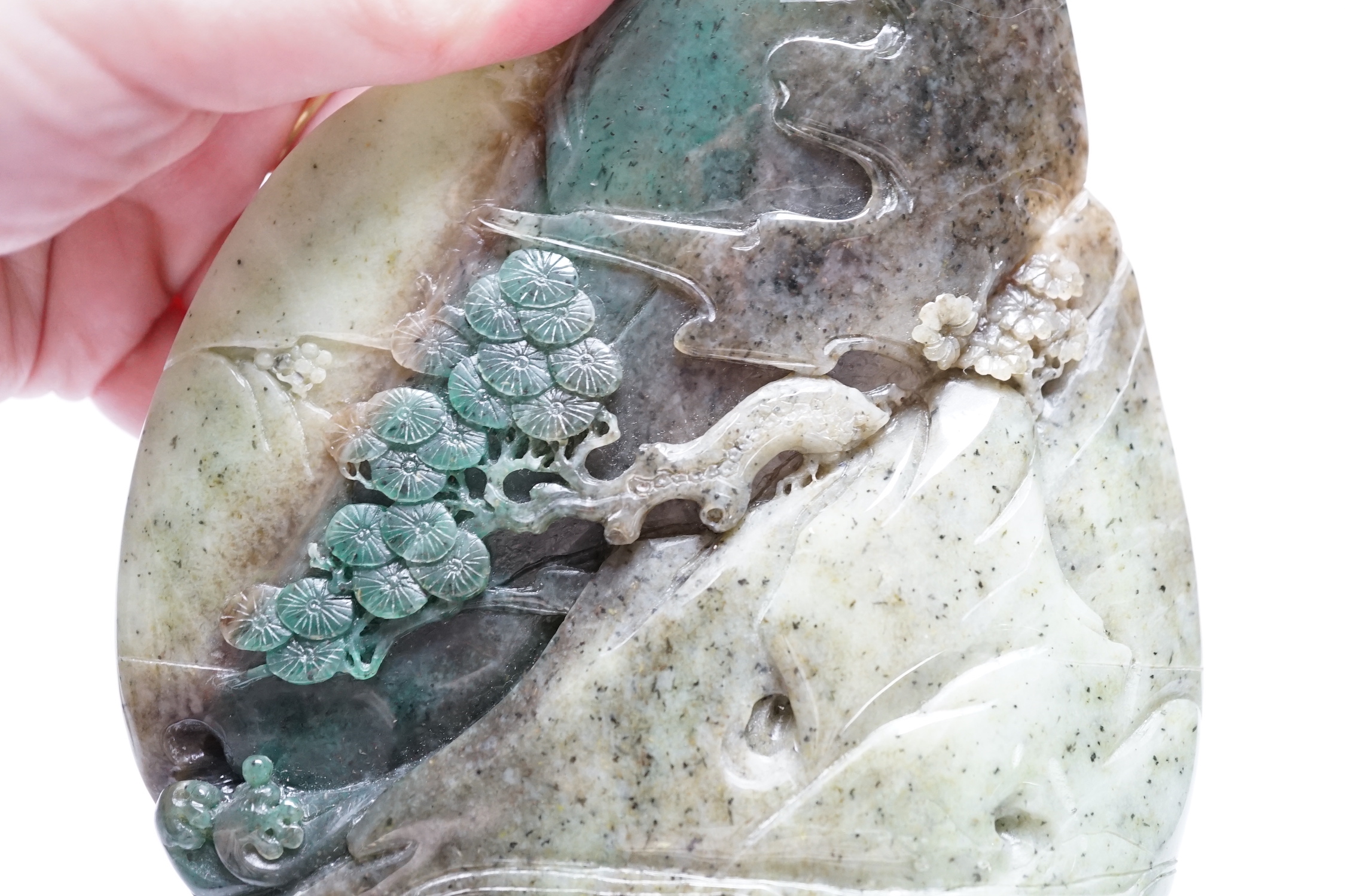 A Chinese jadeite boulder carving on hardwood stand, 17cm high